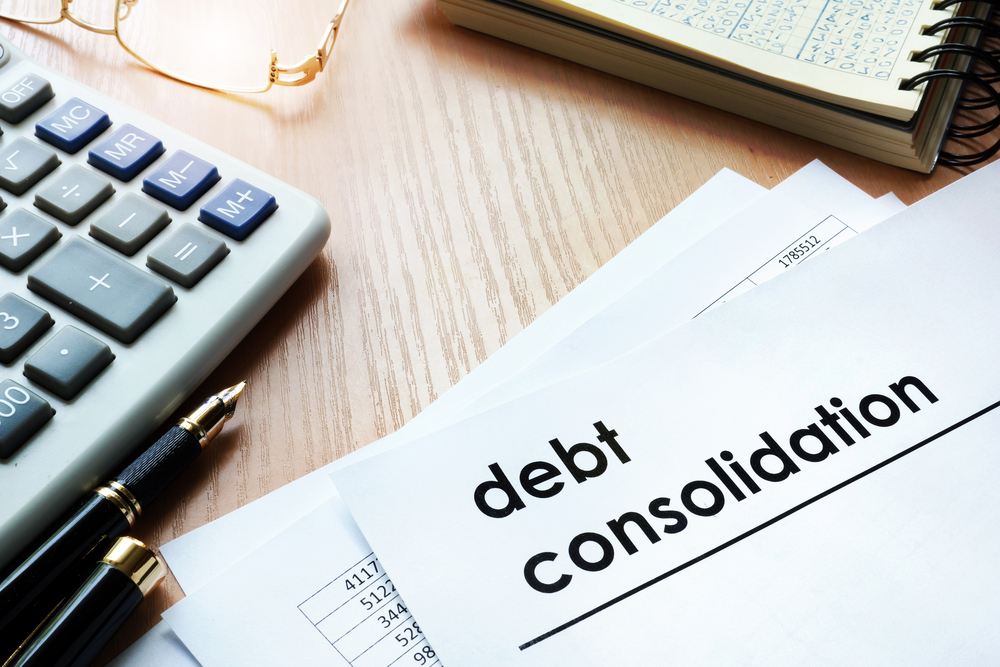 Paper that says Debt Consolidation on a table with a calculator